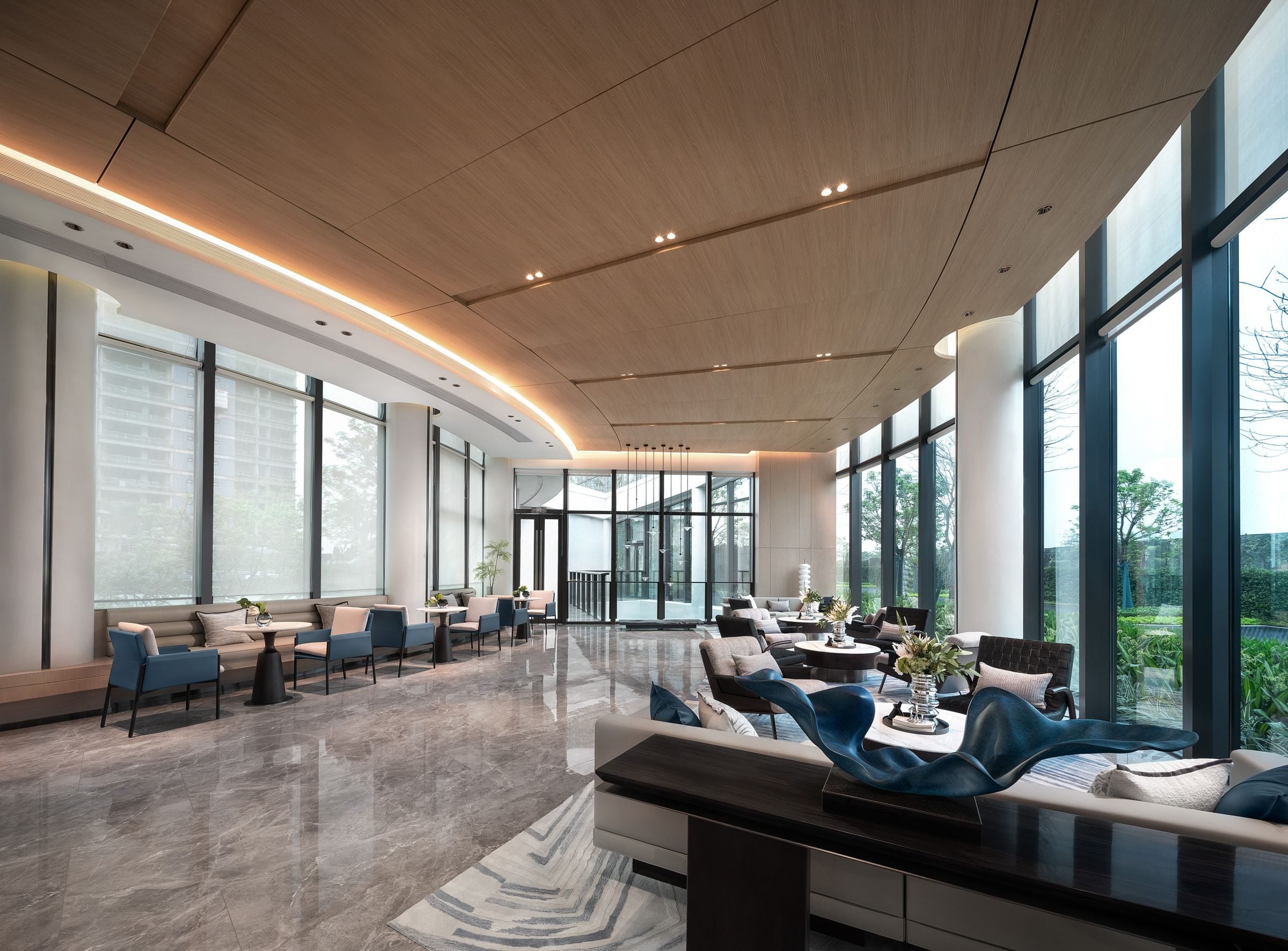 Spacious and elegantly designed luxury hotel lobby with modern furnishings and large windows.