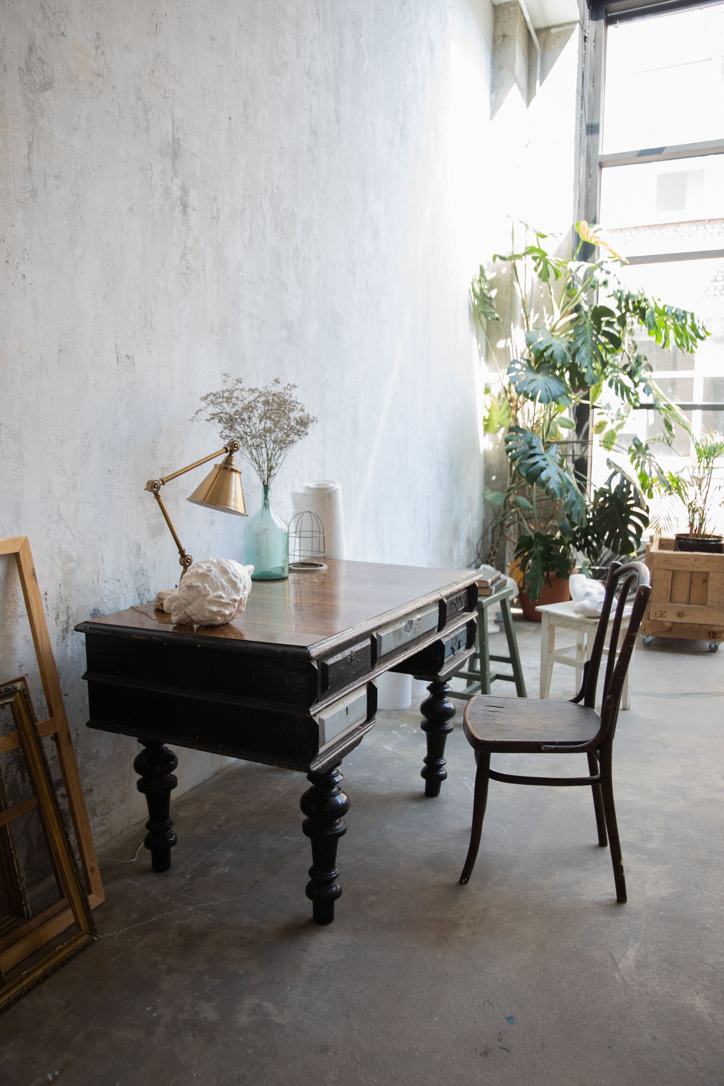 Explore a vintage interior with a classic wooden desk, chair, and natural light.