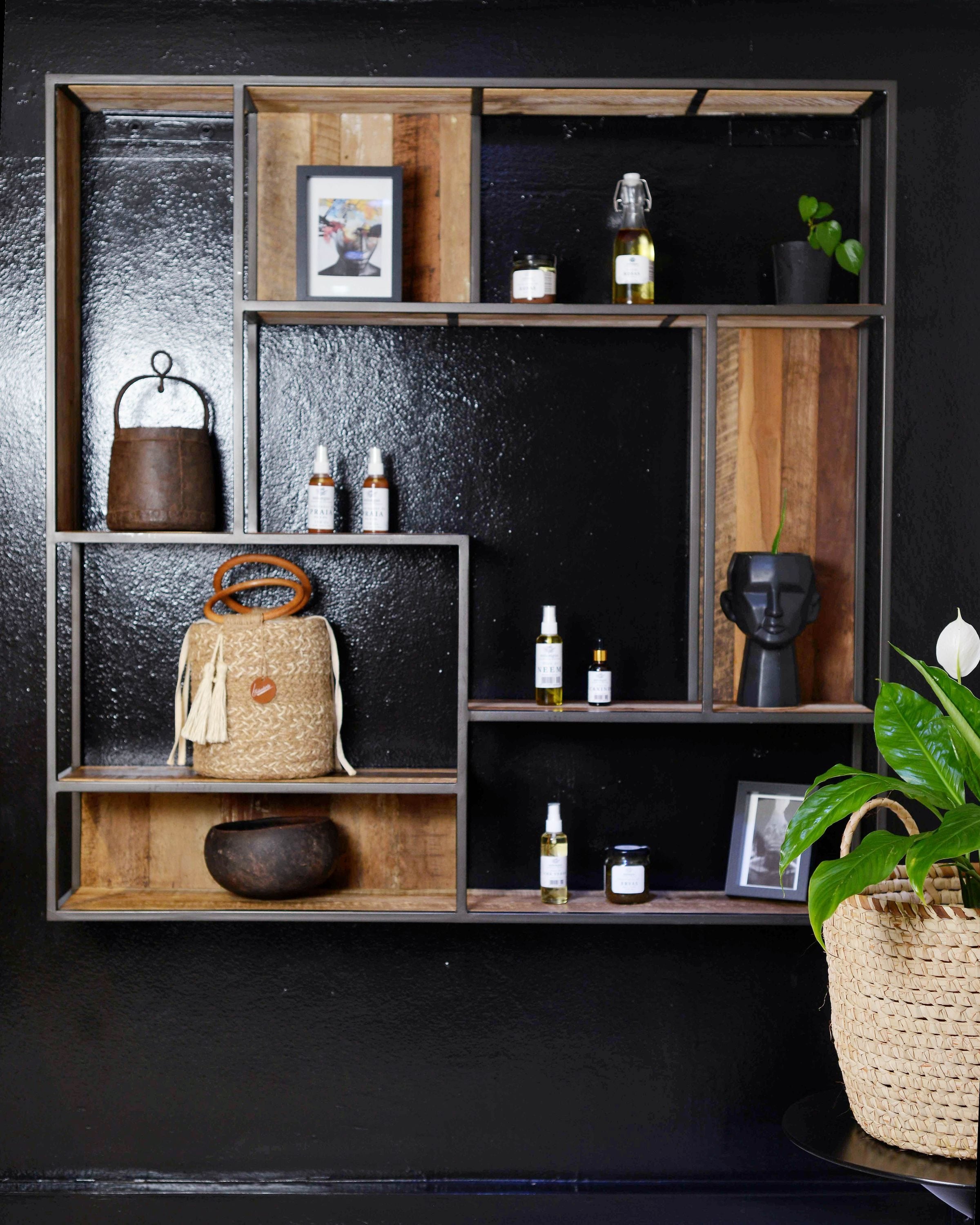 Elegant black and wood shelves featuring decor and plants in a modern interior.